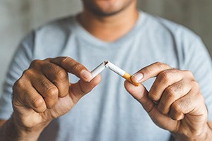 Man breaking cigarette