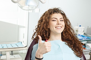 Female dental patient giving thumbs up
