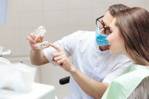 a dentist explaining how dental implants work to a patient