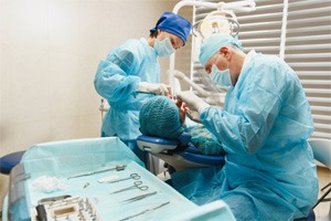an oral surgeon performing the dental implant placement procedure