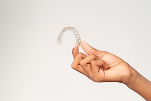 Teenager holding clear aligner