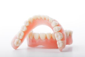 Upper and lower full dentures on white background