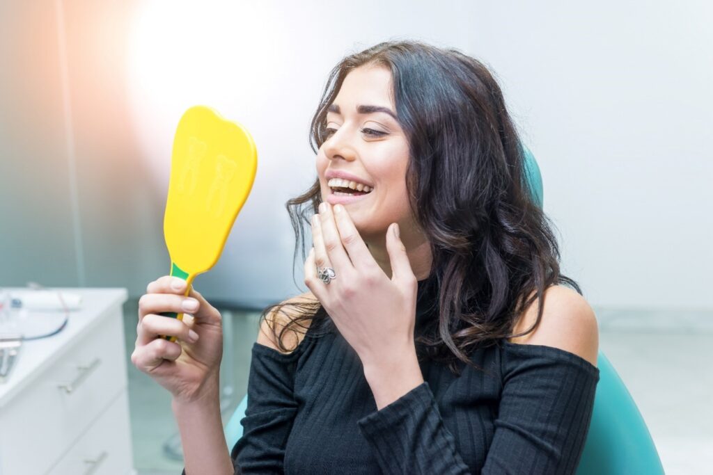 Woman smiling while looking at reflection in mirror